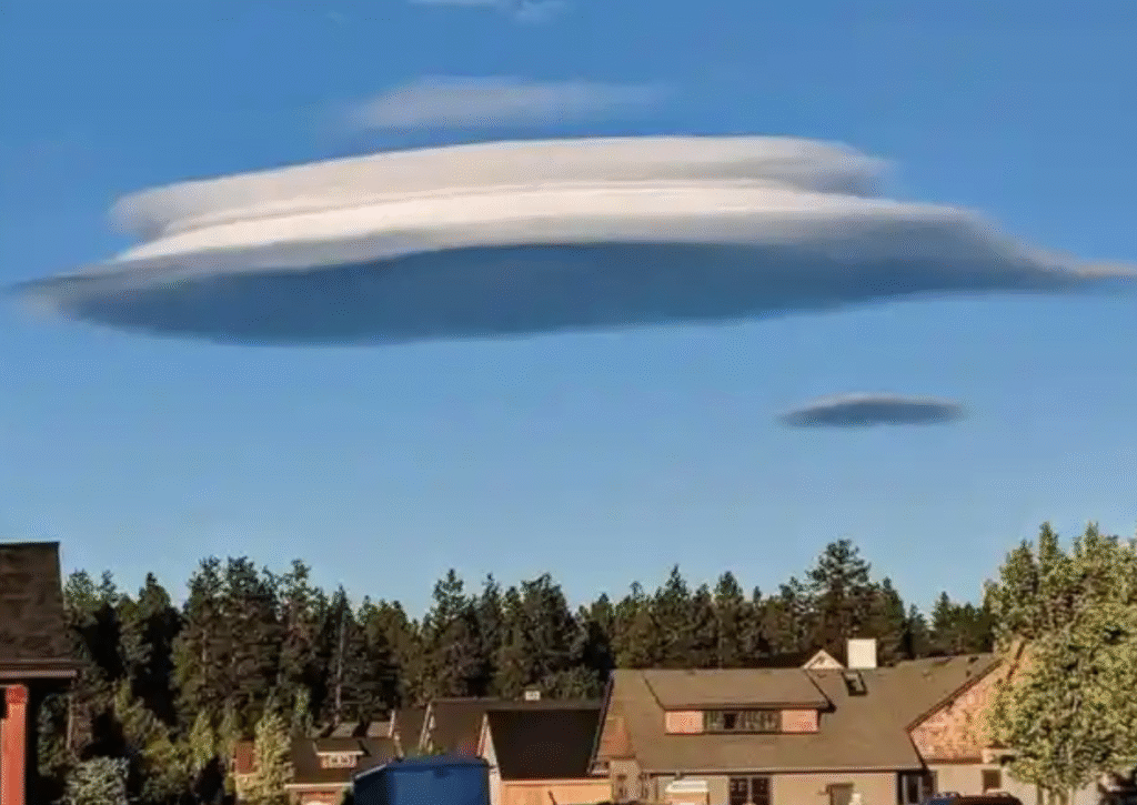 Lenticular cloud in the sky shaped like a flying saucer above houses