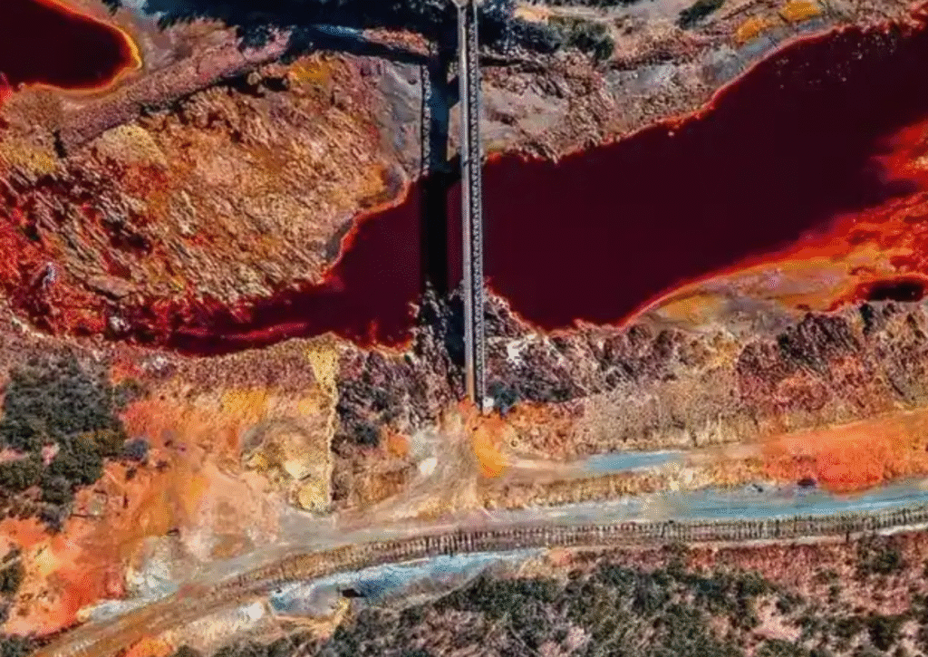 Aerial view of the bright red Rio Tinto river and surrounding colorful terrain
